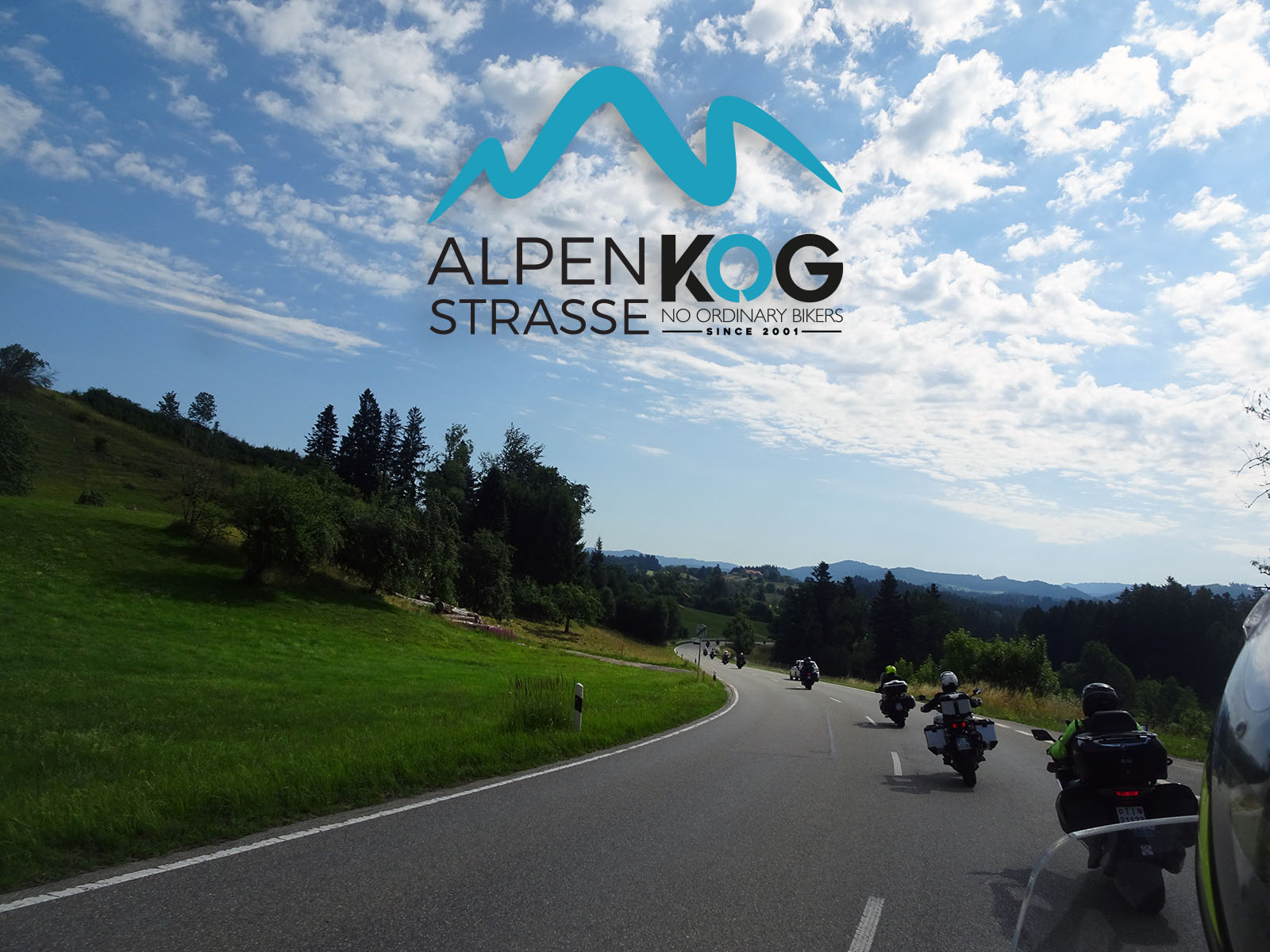 Motociclisti su strada panoramica tra colline verdi